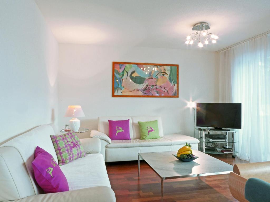 ein Wohnzimmer mit einem weißen Sofa und einem TV in der Unterkunft Apartment Goldenhorn by Interhome in Wengen