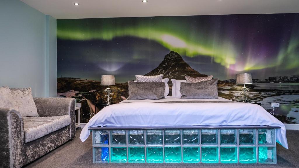 um quarto com uma cama e vista para a aurora boreal em St Hildas Complex em Hinderwell