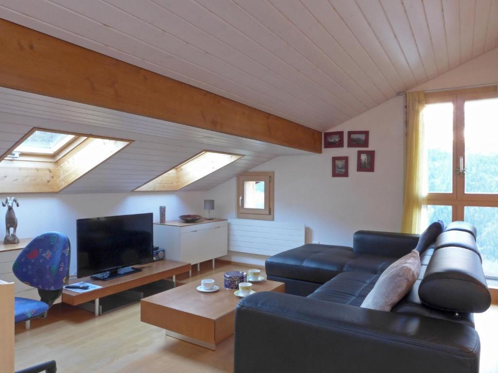 a living room with a couch and a tv at Apartment Breithorn-Residence-3 by Interhome in Wengen