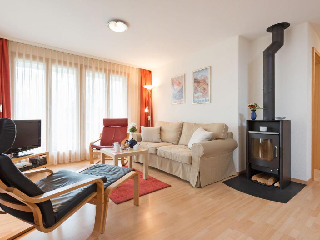 ein Wohnzimmer mit einem Sofa und einem Kamin in der Unterkunft Apartment Silberhorn-2 by Interhome in Wengen