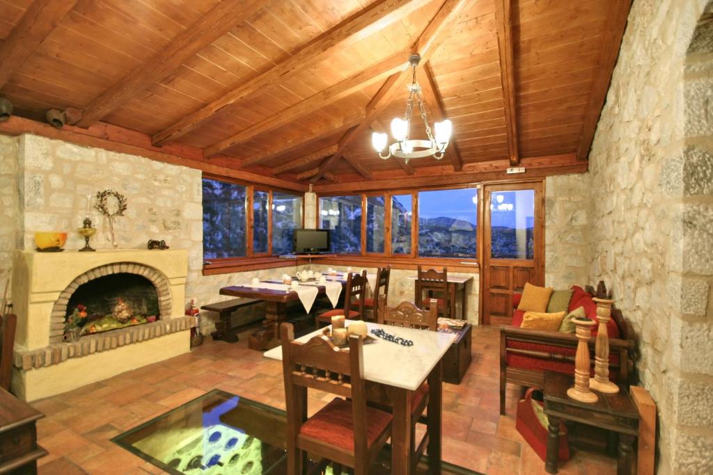 a living room with a fireplace and a table and chairs at Archontiko Kolokotroni in Stemnitsa