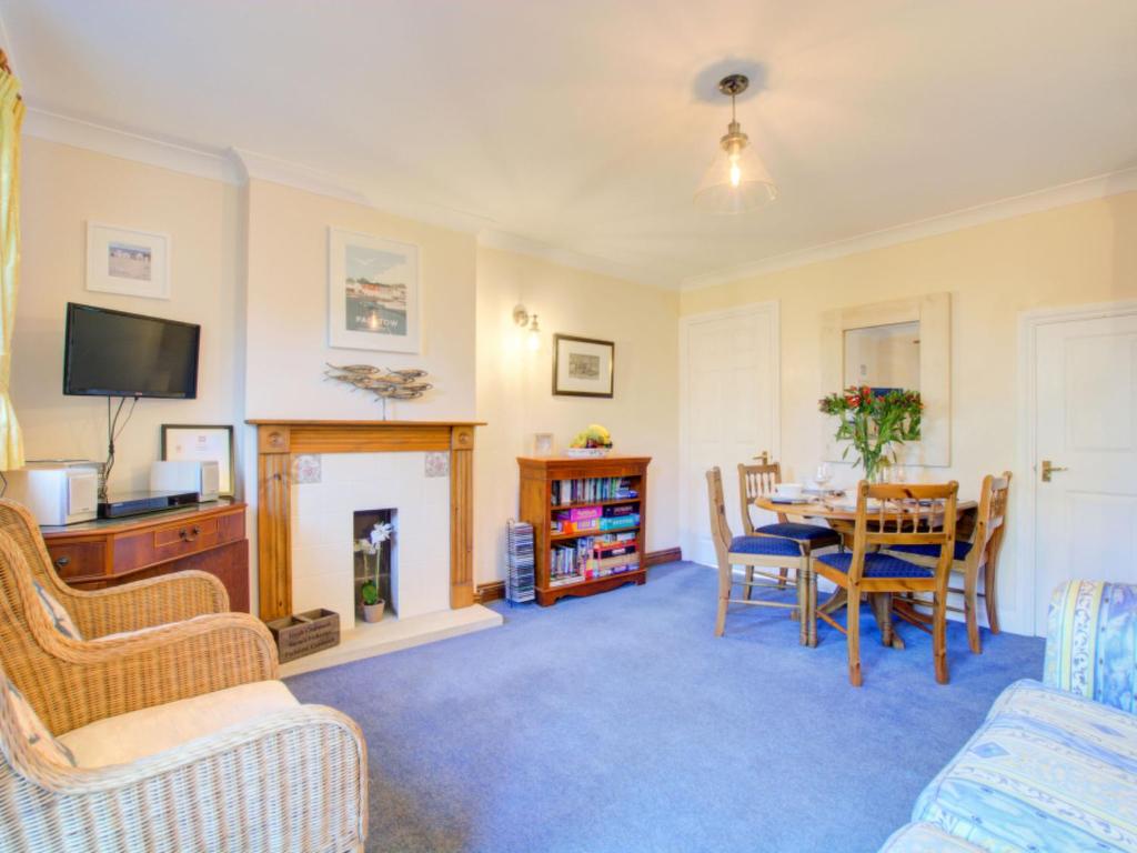 a living room with a table and a fireplace at Holiday Home June Cottage by Interhome in Padstow