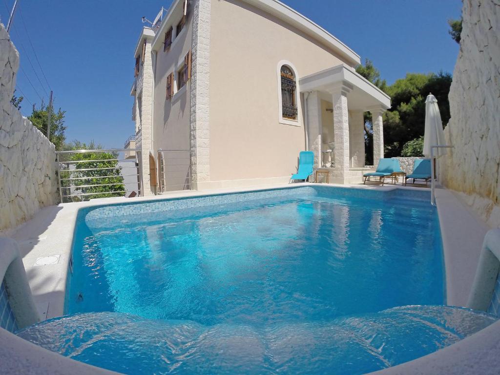 a swimming pool in front of a house at Holiday Home Villa Mustra by Interhome in Okrug Donji