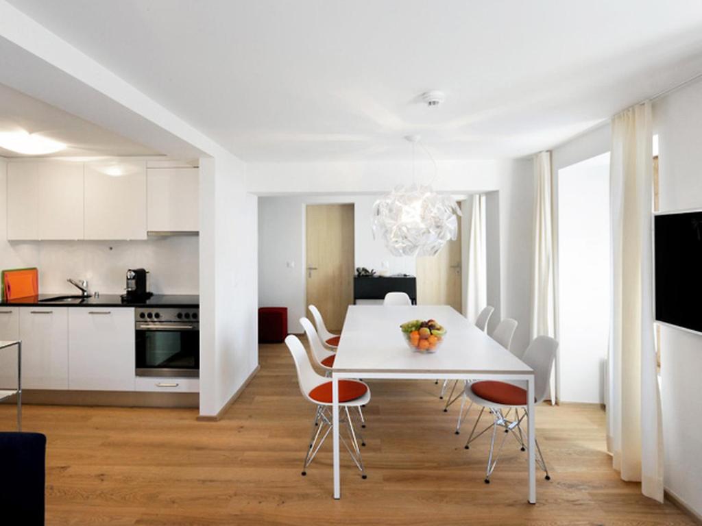 a white dining room with a white table and chairs at Apartment Sternen B by Interhome in Lenk