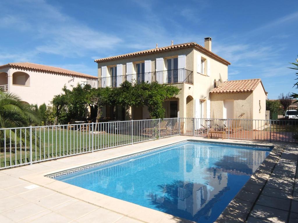 eine Villa mit einem Swimmingpool vor einem Haus in der Unterkunft Holiday Home Villa Brigantin by Interhome in Plage dʼArgelès