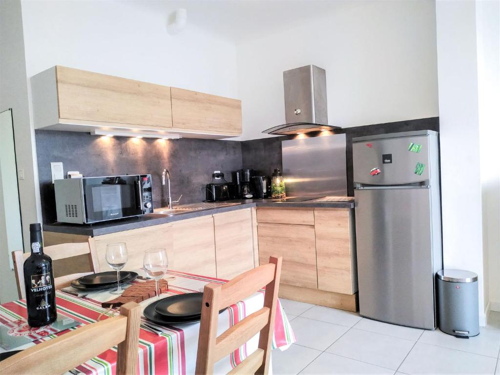 a kitchen with a table and a stainless steel refrigerator at Apartment Berasteguia-2 by Interhome in Saint-Jean-de-Luz