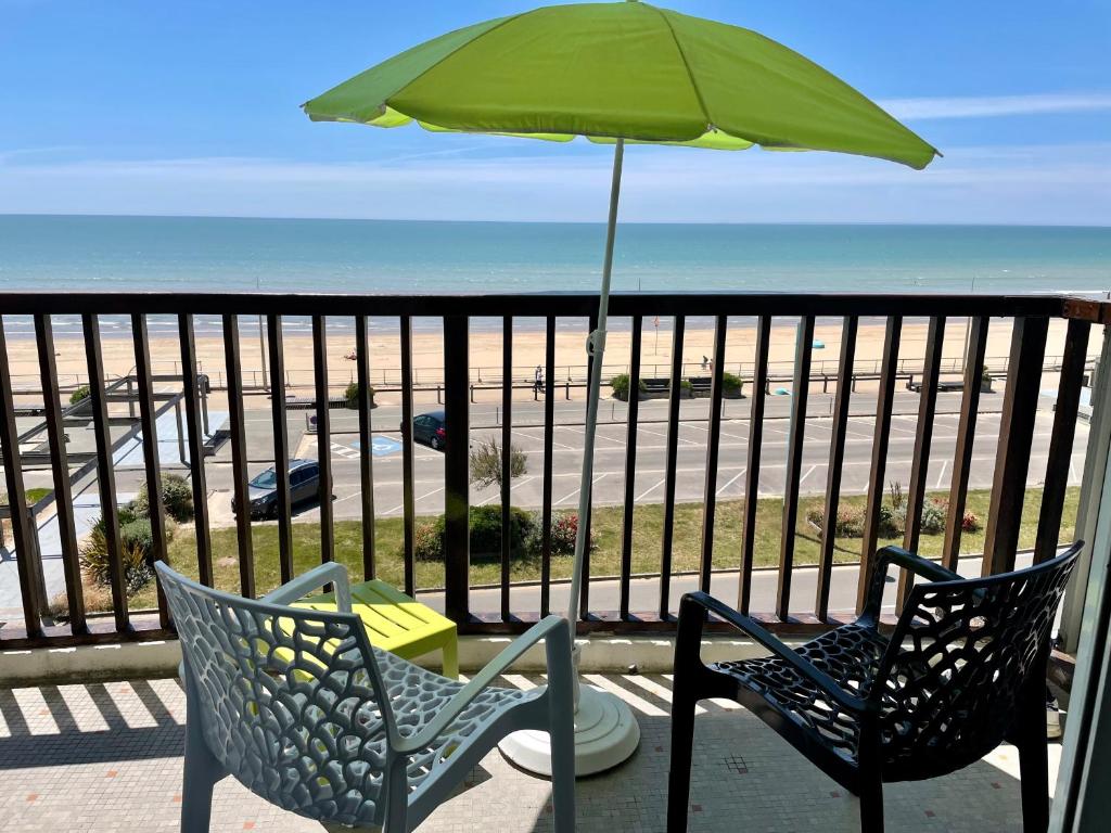 - deux chaises et un parasol sur le balcon donnant sur la plage dans l'établissement Résidence Orphé A, à Saint-Jean-de-Monts