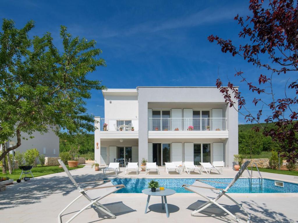 a villa with a swimming pool and a house at Villa Chiara by Interhome in Diminići