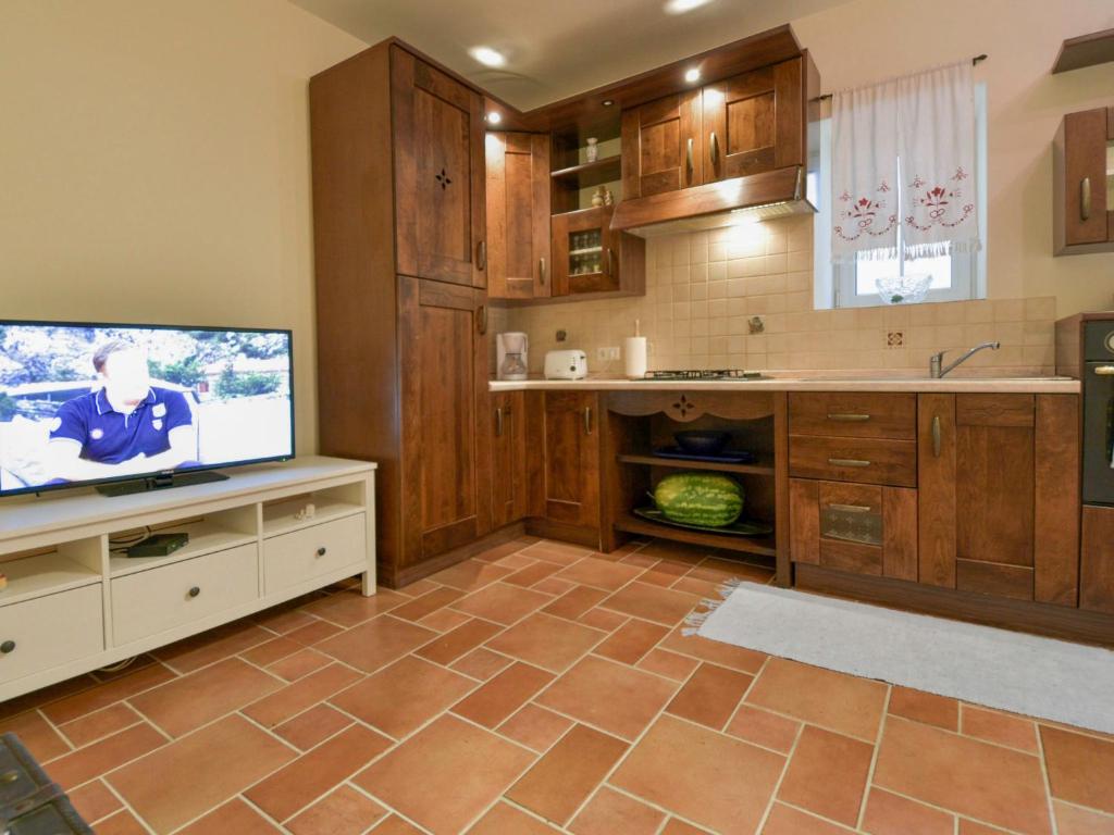 kuchnia z telewizorem z płaskim ekranem i drewnianymi szafkami w obiekcie Holiday Home Mali dvori by Interhome w mieście Diklo