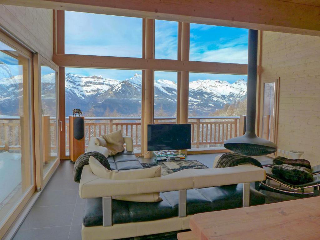 a living room with a view of snow covered mountains at Chalet Woovim 8 by Interhome in Nendaz
