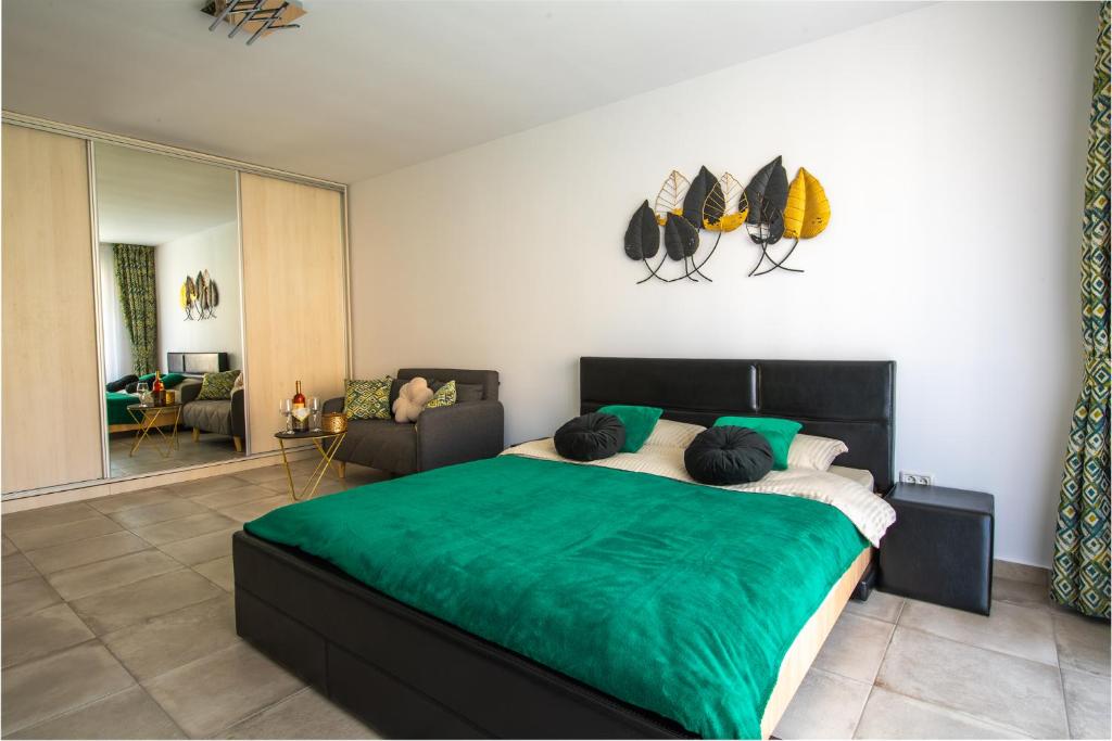 a bedroom with a large bed with a green blanket at CITY VIBE STUDIO in Braşov