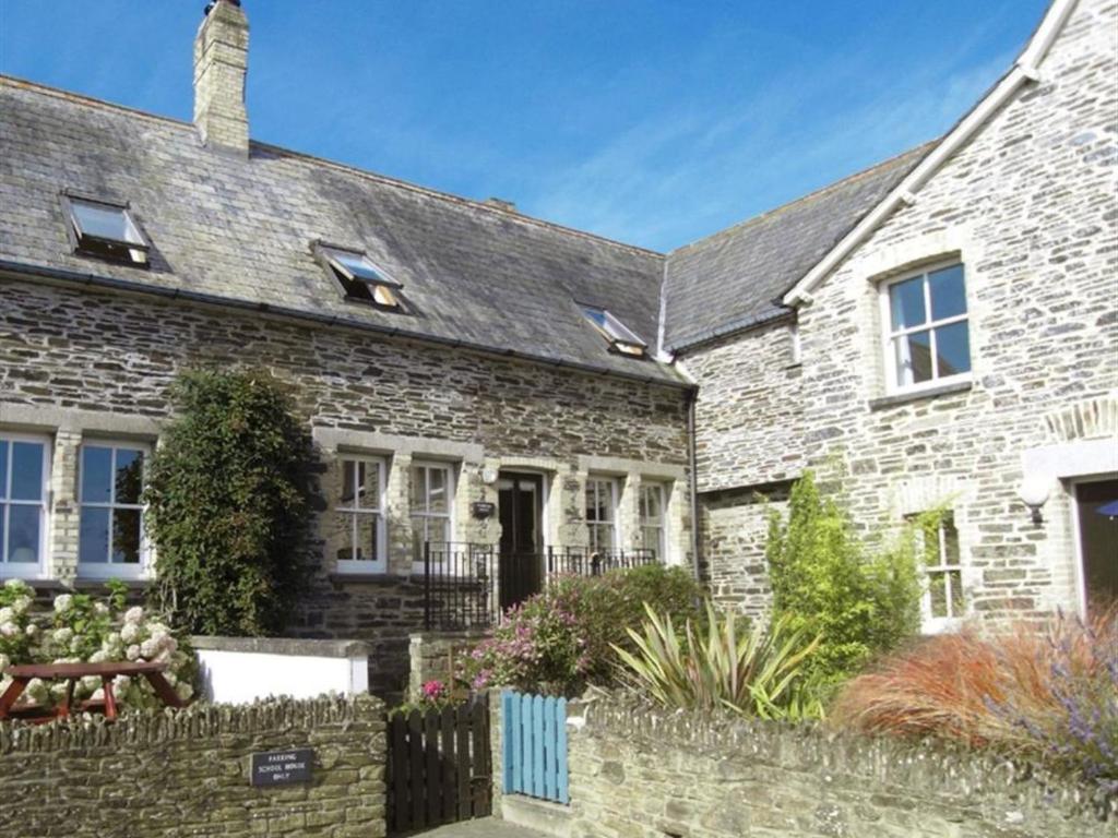 a stone house with a fence in front of it at Holiday Home Old School House by Interhome in Padstow