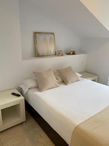 Un dormitorio con 2 camas y una mesa con una foto en la pared. en Apartamento Marina Llanes III, en Llanes