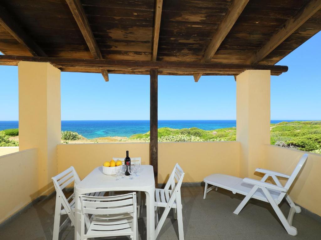 - une table et des chaises sur une terrasse couverte offrant une vue sur l'océan dans l'établissement Apartment Ananas 4 D by Interhome, à Valledoria