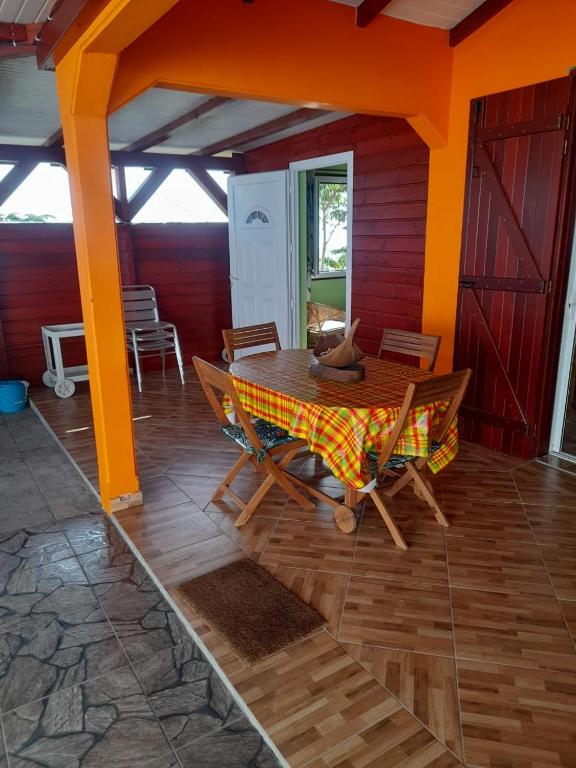 een eetkamer met een tafel en stoelen in een huis bij Pomme cannelle in Bouillante