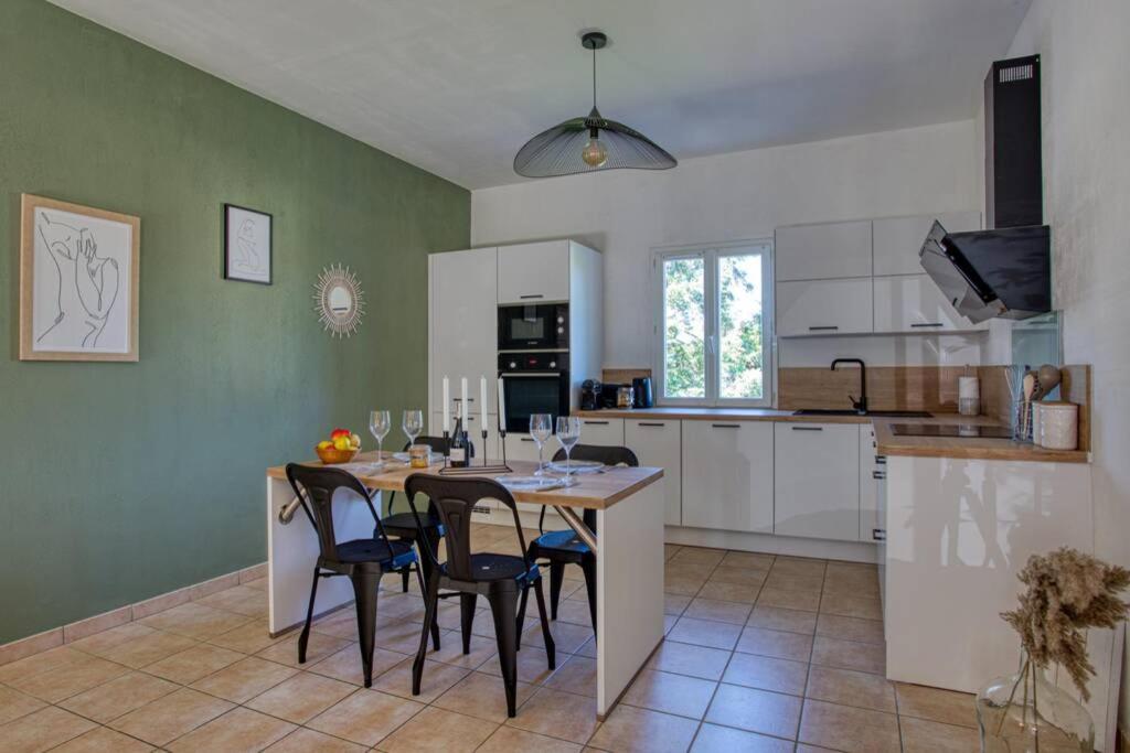 een keuken met een tafel en stoelen in een kamer bij SARLAT - 24 - L'appartement d'Euphé avec piscine in Sarlat-la-Canéda
