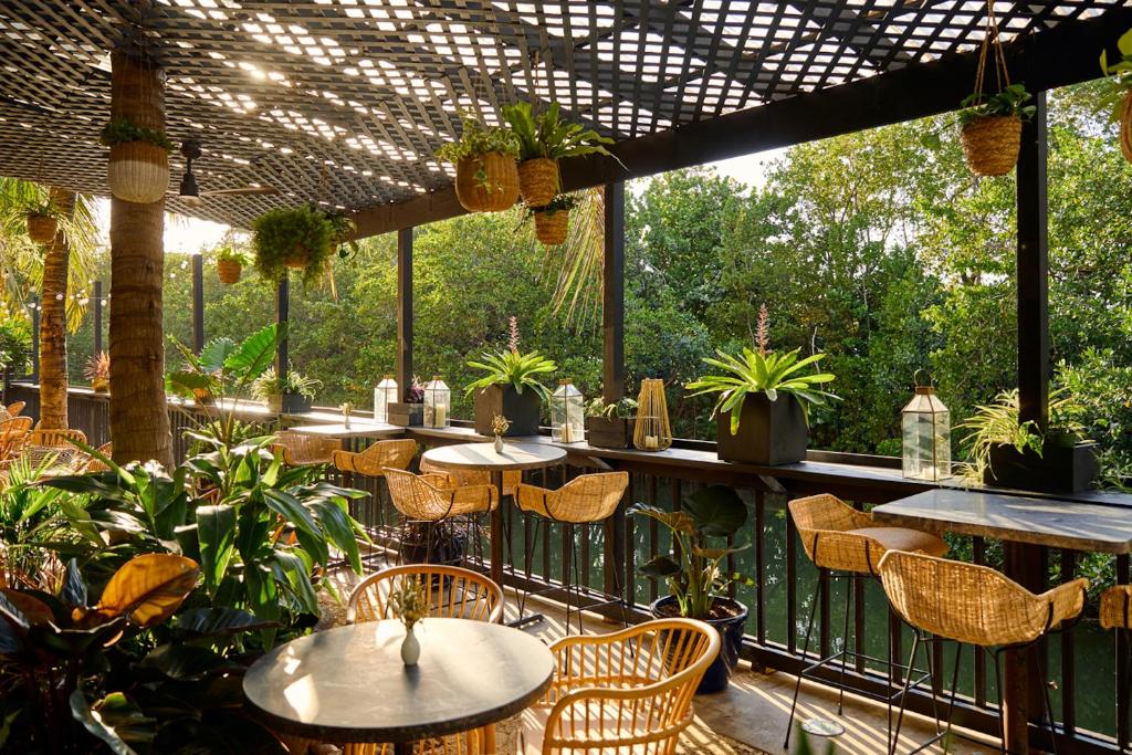 an outdoor patio with tables and chairs and plants at KAYAK Miami Beach in Miami Beach