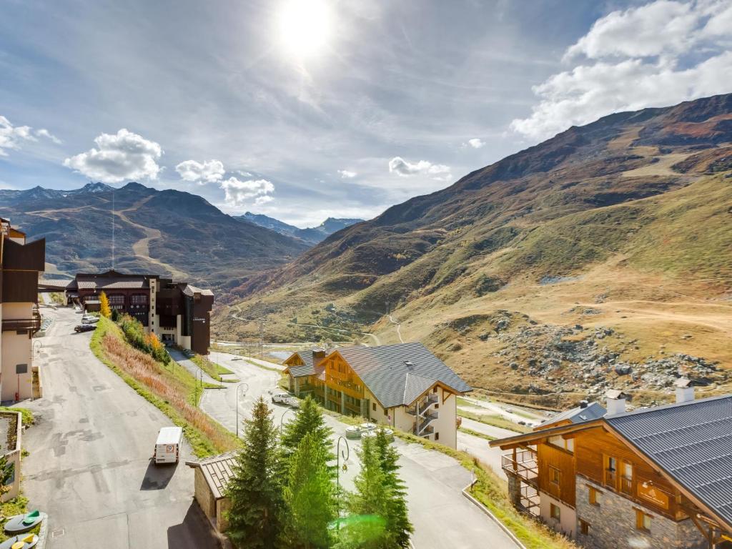 un village de montagne avec une route, des bâtiments et des montagnes dans l'établissement Apartment Ski Soleil 1 - 1511 by Interhome, aux Menuires