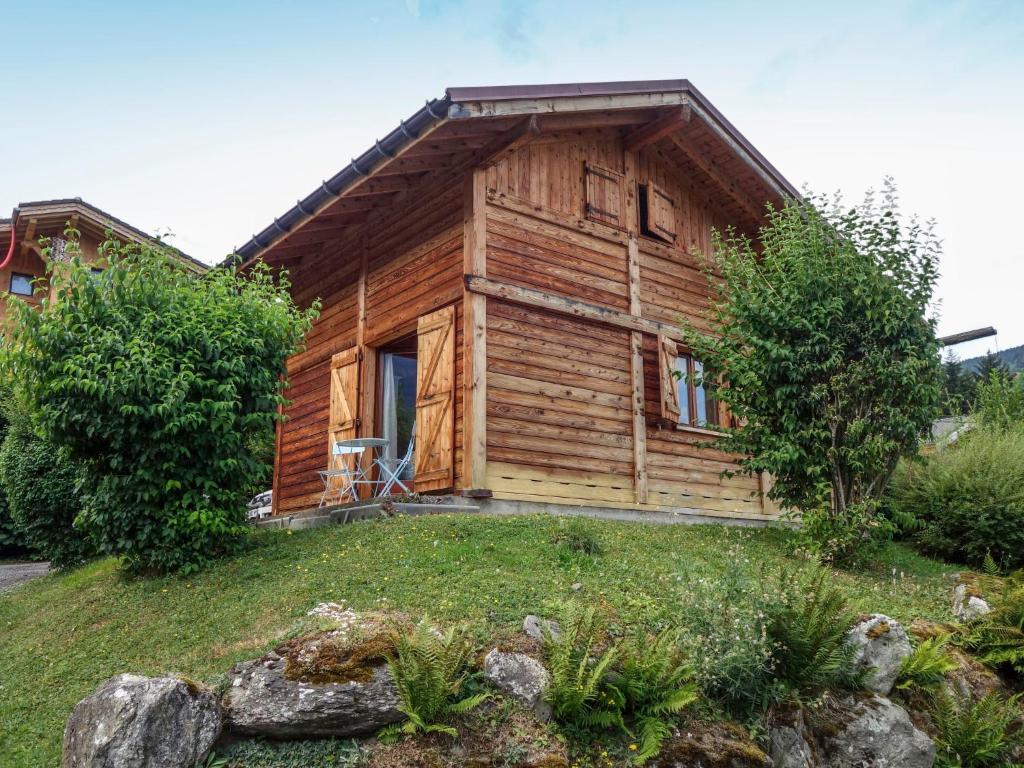 ein Holzhaus auf einem Hügel mit einem Hof in der Unterkunft Holiday Home Les Farfadets by Interhome in Saint-Gervais-les-Bains
