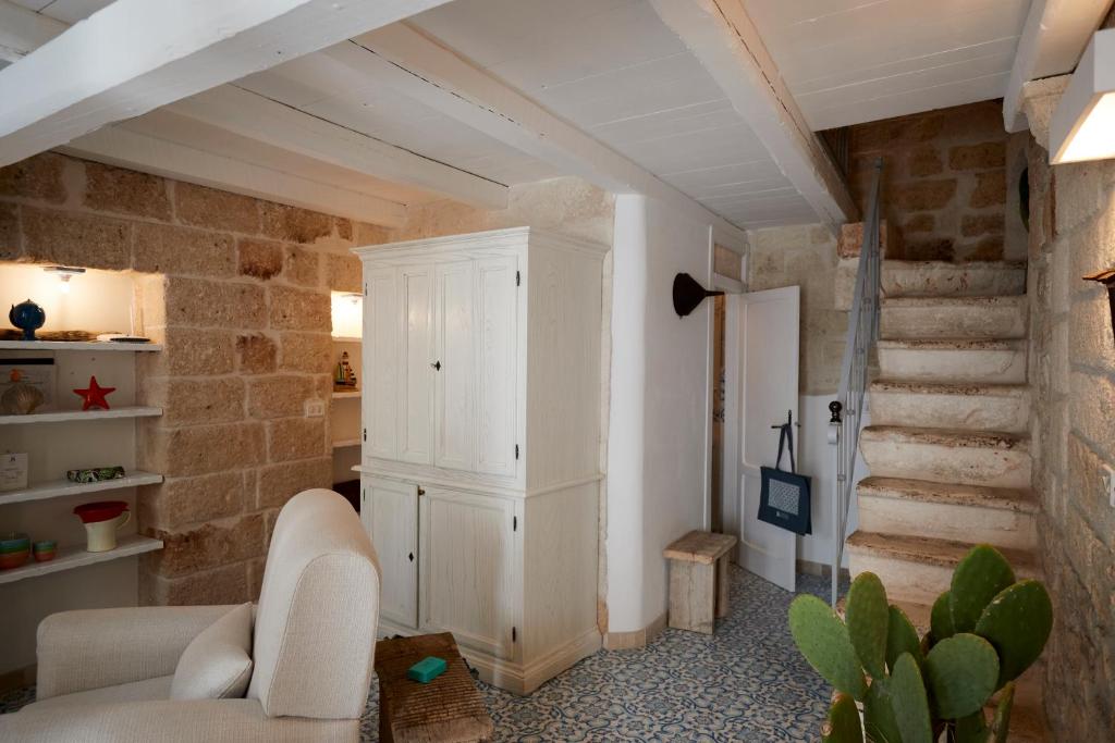 a living room with a white cabinet and stairs at Dei Serafini in Polignano a Mare