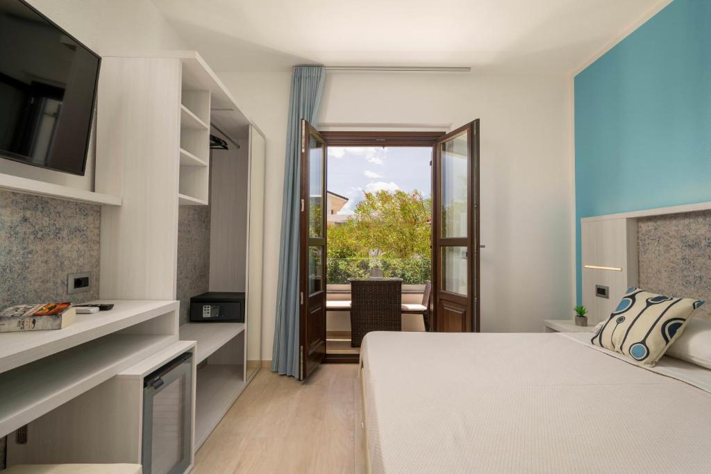 a hotel room with a bed and a window at Hotel Ristorante La Conchiglia in Cala Gonone