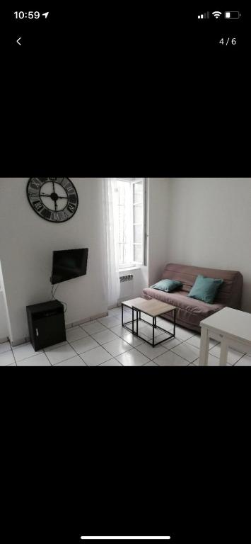 un salon avec un canapé et une horloge au mur dans l'établissement Le Studio Rochelais, à La Rochelle