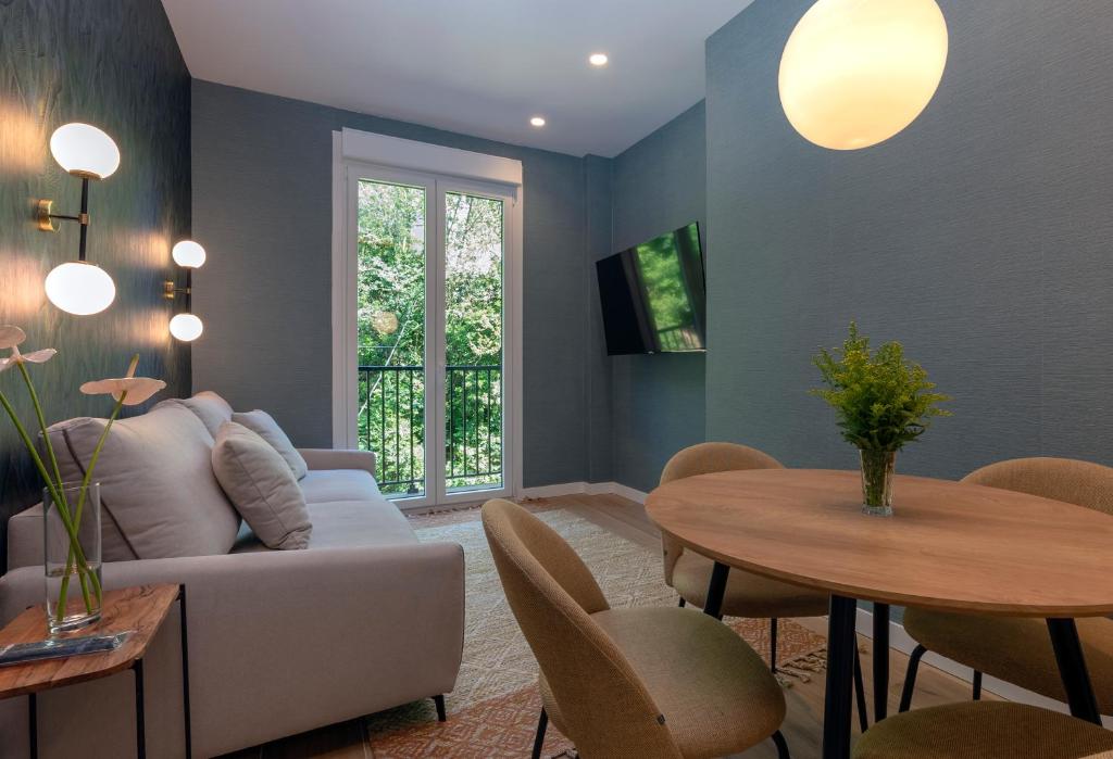 uma sala de estar com um sofá e uma mesa em BIG 4 ROOMS in a Centric Home Parking Included em San Sebastián