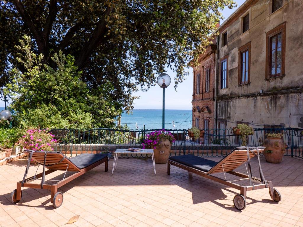 2 chaises et une table en face d'un bâtiment dans l'établissement Villa Gabriella by Interhome, à Formia