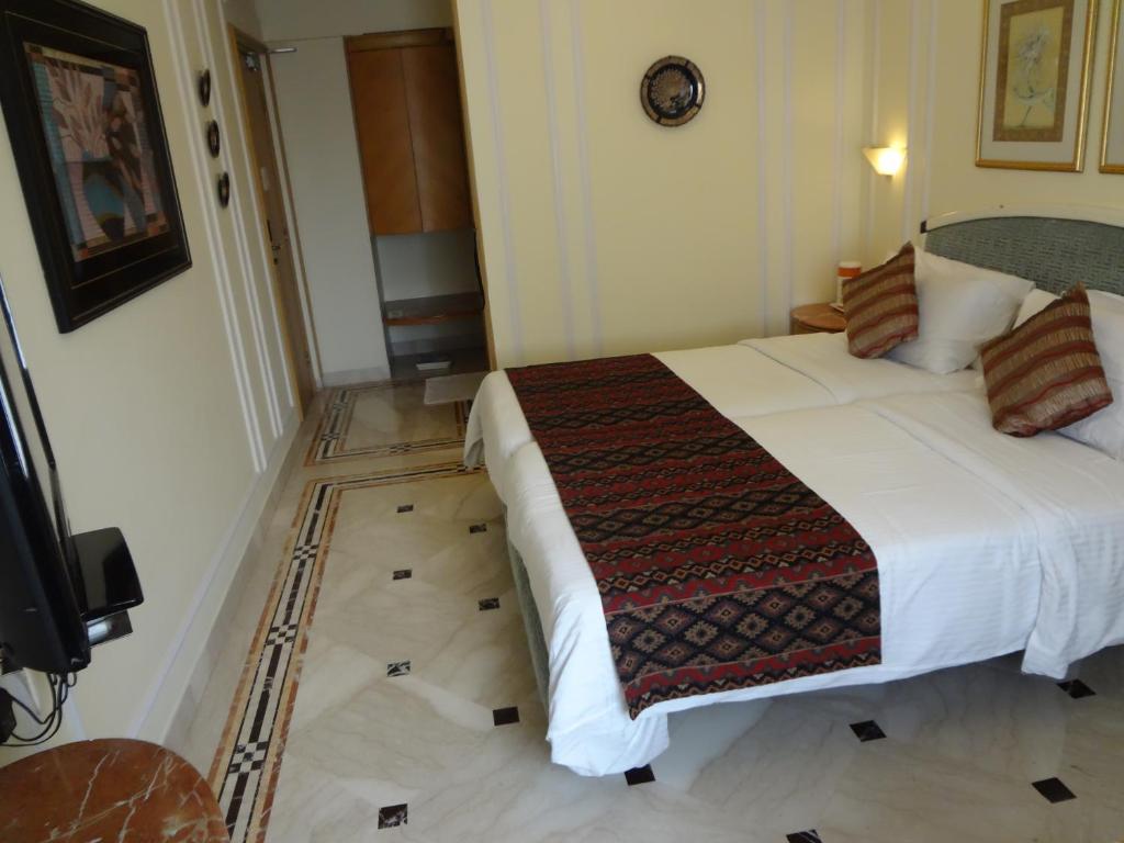 Postel nebo postele na pokoji v ubytování Regency Hotel Malabar Hill
