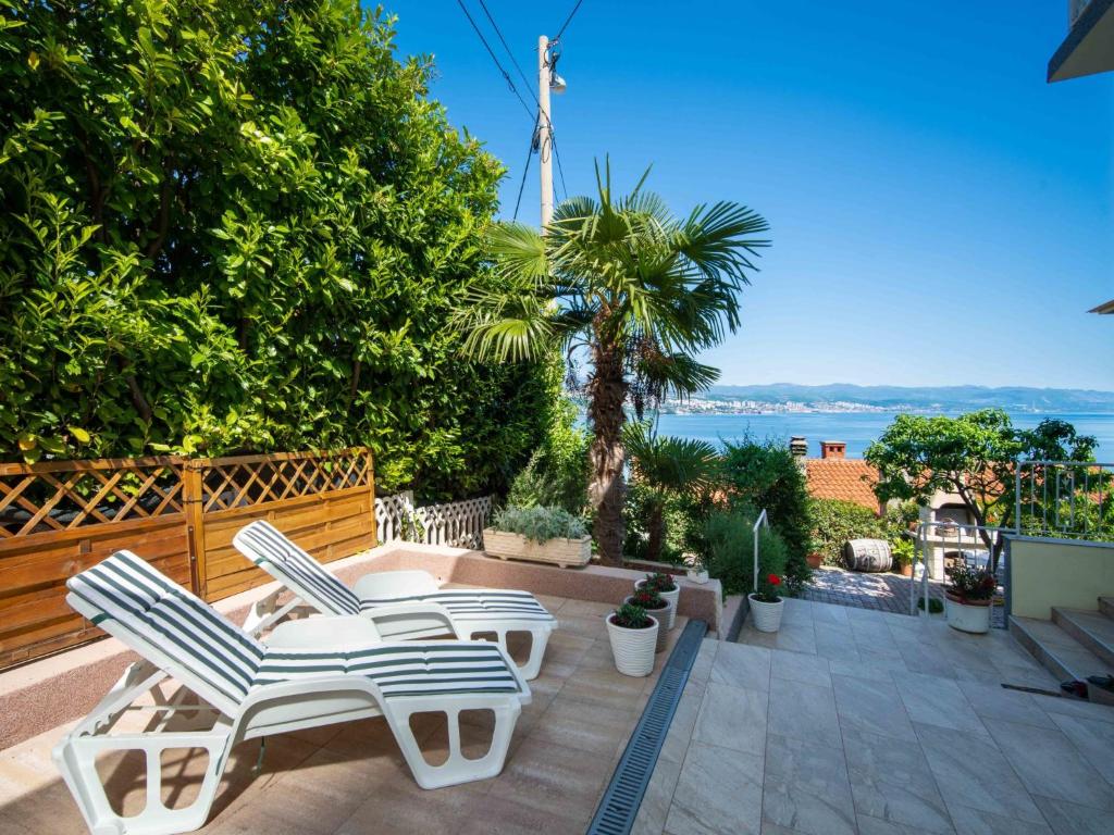 a patio with two lounge chairs and the ocean at Holiday Home Bono by Interhome in Opatija