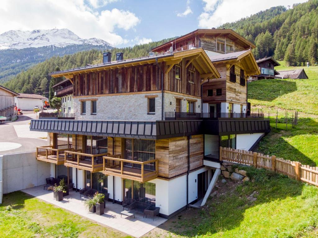 a house on a hill with mountains in the background at Studio The PEAK-8 by Interhome in Sölden