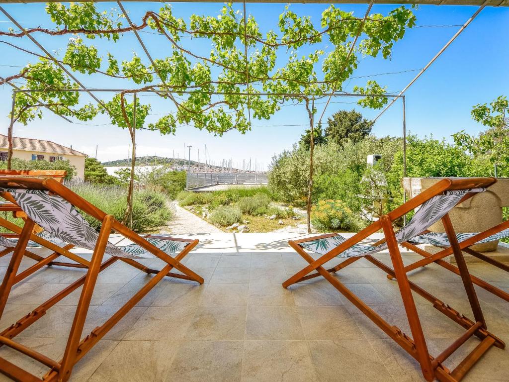 two chairs on a patio with a view of a bridge at Holiday Home Mihotić by Interhome in Murter