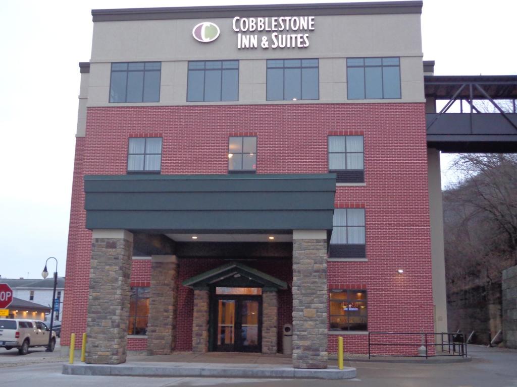 Marquette的住宿－Cobblestone Inn & Suites - Marquette，红砖建筑,上面有标志
