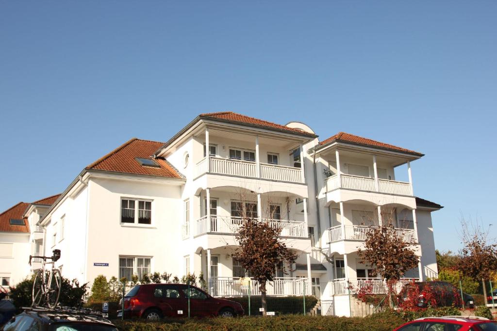 a large white building with a red roof at Ferienwohnung am Potenberg FeWo 6 - Balkon in Binz