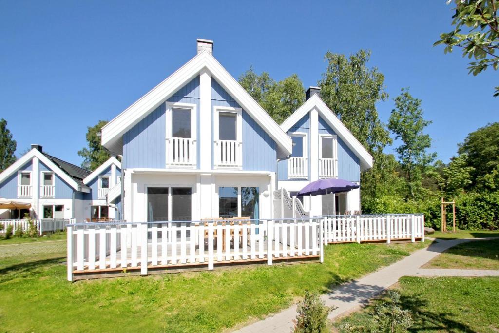 a large white house with a white fence at Ferienhaus Cumulus Haus - strandnah, Terrasse, Sauna in Drewoldke