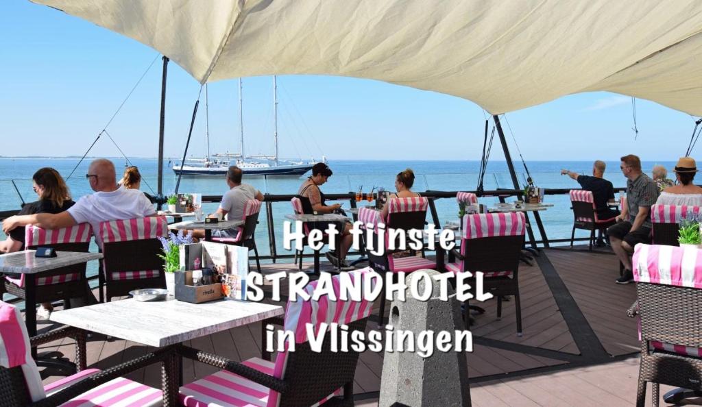 een groep mensen die aan tafels op een dek zitten bij Hotel Truida in Vlissingen