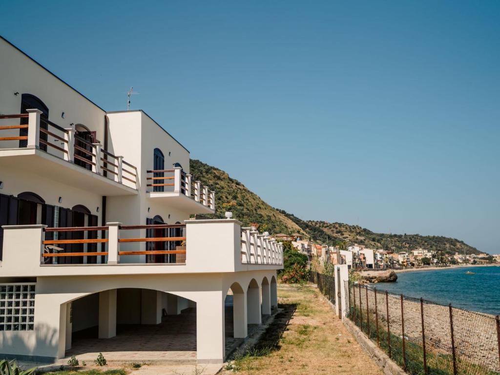 um edifício branco com varandas com vista para o oceano em Apartment Pinta by Interhome em Caronia Marina