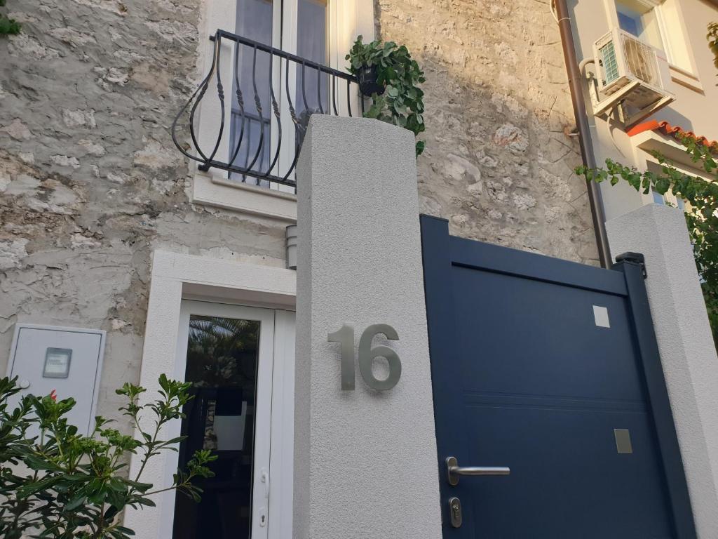 a house with a blue door and a balcony at CASTEL in Mali Lošinj