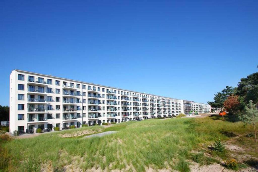 a large white apartment building on top of a grassy hill at Ostseeresort Binz Prora in Binz