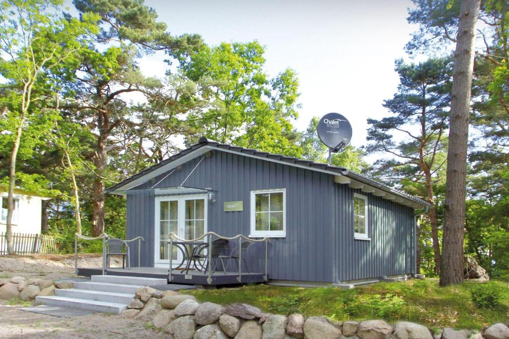 ein kleines Haus mit einer Veranda und einem Tisch in der Unterkunft Chalet Ostsee Haus Nr. 72 in Göhren