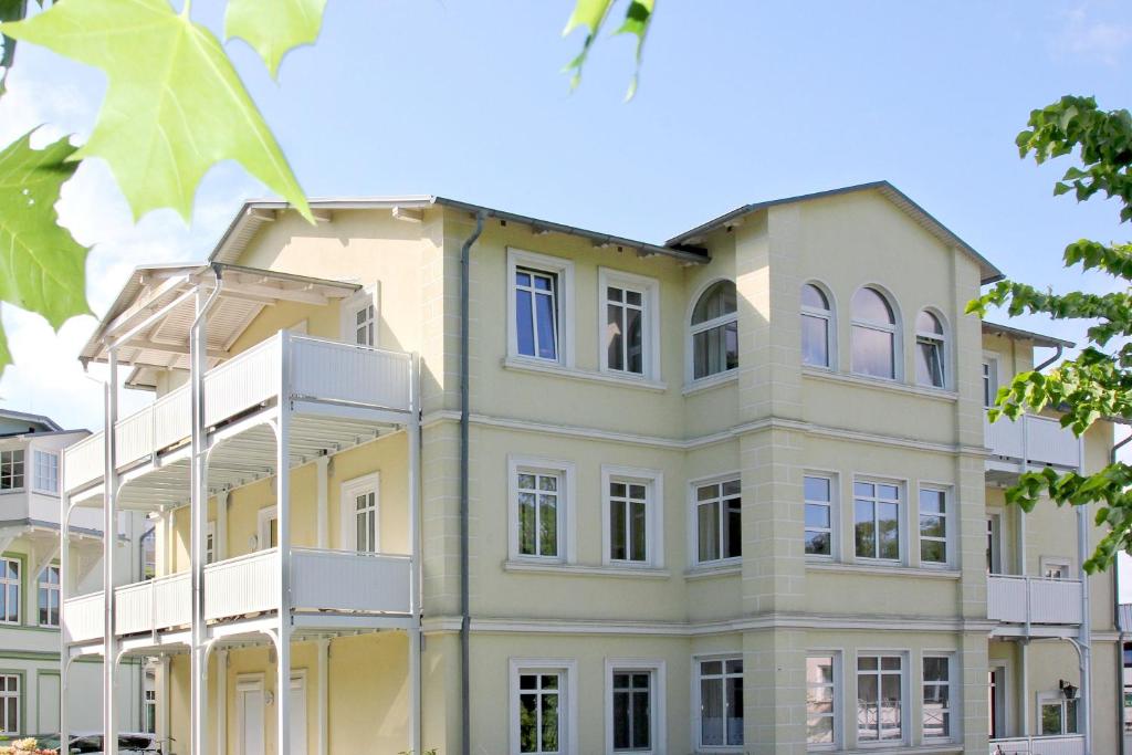 ゲーレンにあるstrandnah, mit Balkon und AHOI Erlebnisbad in Sellin gratis - Villa Strandmuschel FeWo 08の黄白のアパートメントビル