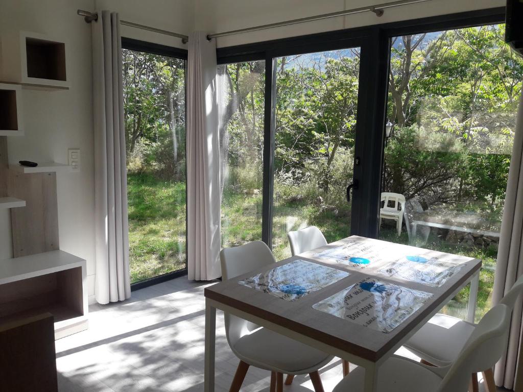 een eetkamer met een tafel en stoelen en een groot raam bij Bungalow Deluxe Mulhacén in Trevélez