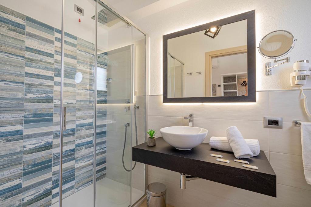 a bathroom with a sink and a glass shower at Hotel Ristorante La Conchiglia in Cala Gonone