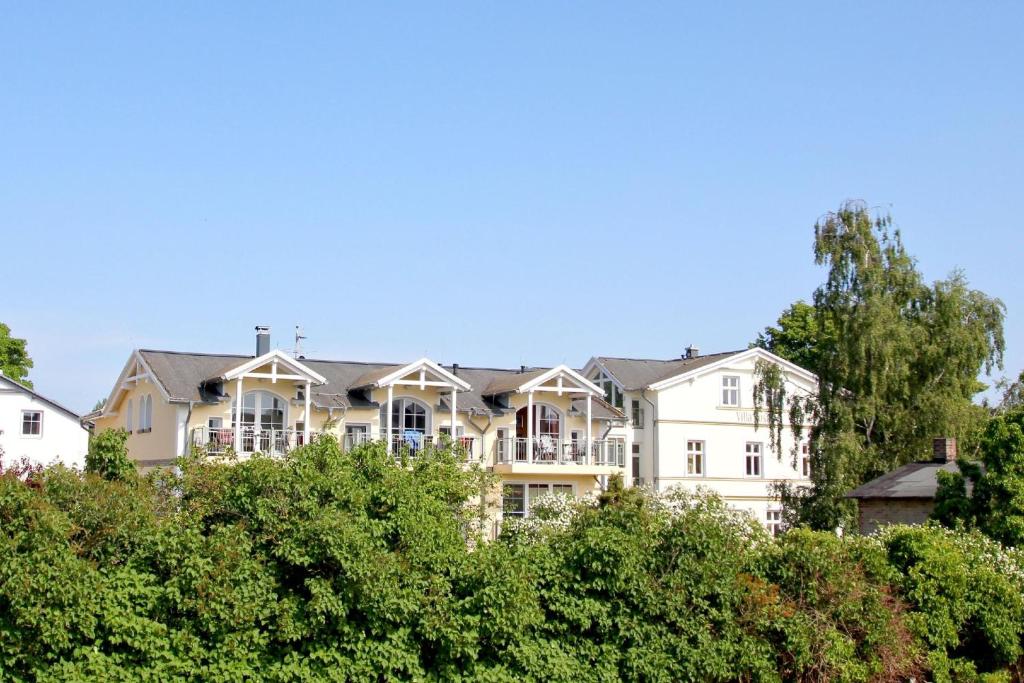グロヴェにあるStrandvilla Boeck Wohnung Nr 15の手前に木々が植えられた大きなアパートメントビル