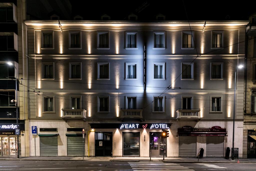 a white building with lights on the side of it at Heart Hotel Milano in Milan