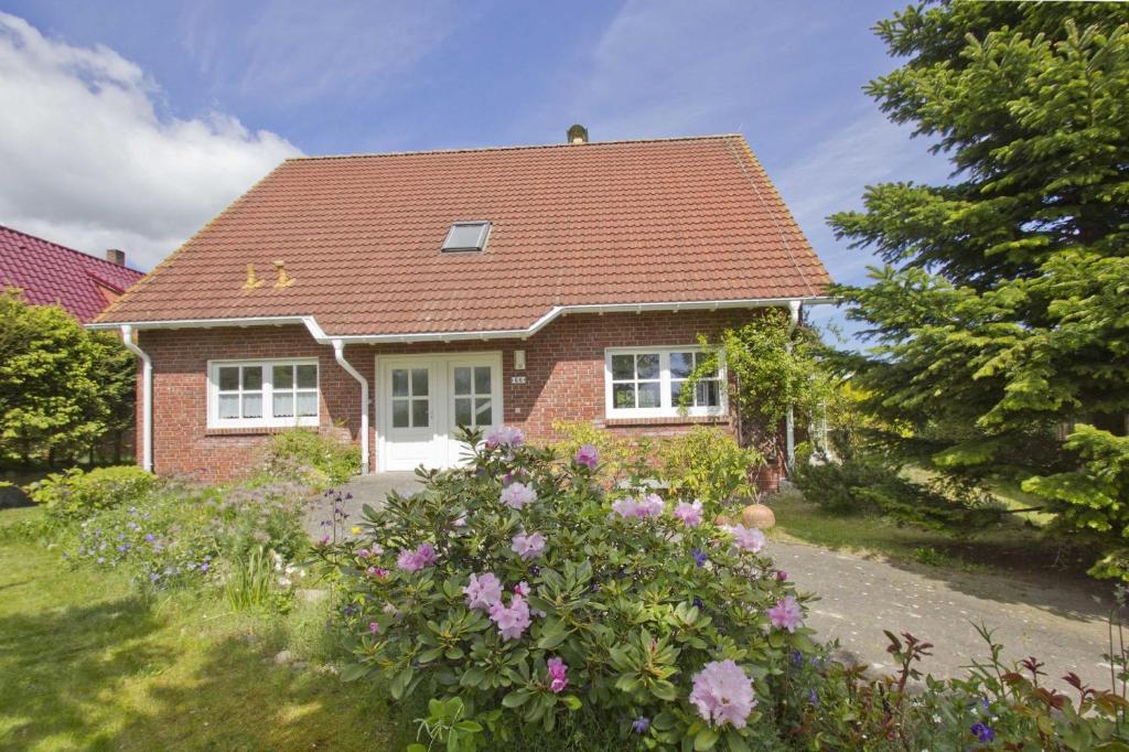 una casa in mattoni con tetto rosso e alcuni fiori di Ferienhaus Gisela Gartenblick - Terrasse, Garten, Sauna a Putbus