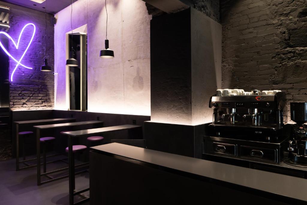 a restaurant with a bar with purple lights at Heart Hotel Milano in Milan