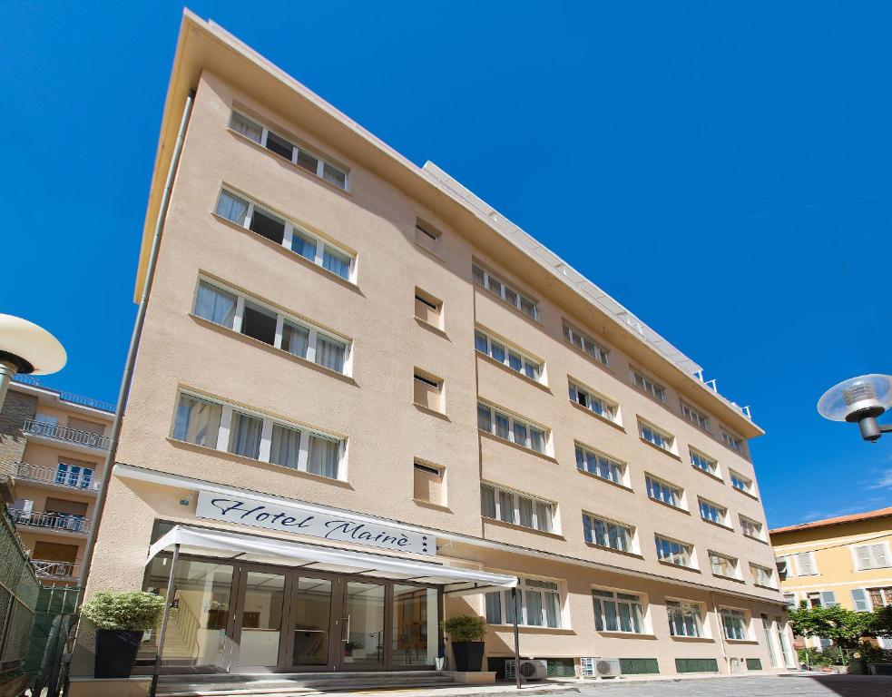 a large tan building with a sign on it at Hotel Mainè in Finale Ligure