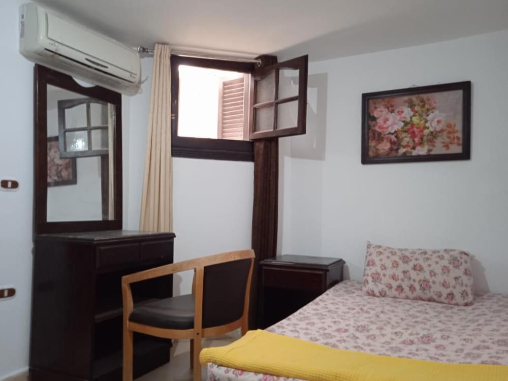 エル・アラメインにあるAL saha2 Basement Chalets villa114 Green Beachのベッドと椅子と窓のある寝室
