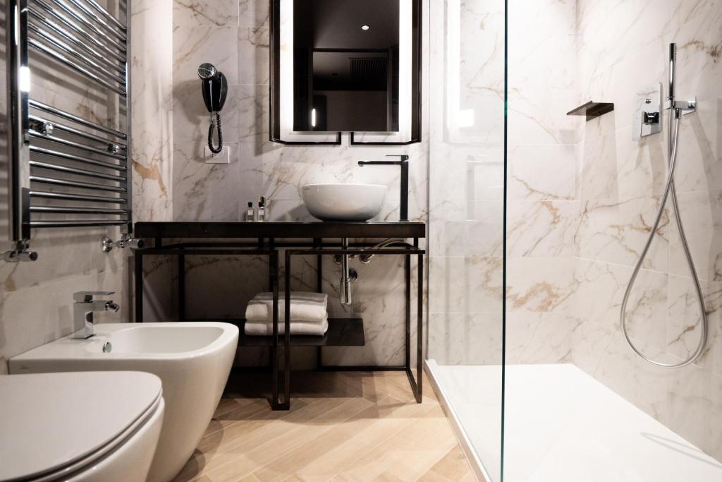 a bathroom with a sink and a toilet and a mirror at Heart Hotel Milano in Milan